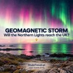 Northern lights over a rocky Scottish coast during the October 2026 geomagnetic storm, a woman photographing the aurora with a phone on a tripod